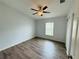 This bedroom has hard wood floors, a ceiling fan, a window, and baseboard trim at 3303 Victory Palm Dr, Edgewater, FL 32141