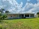 The back of the house is displayed with a screened in porch, patio, and green yard at 3303 Victory Palm Dr, Edgewater, FL 32141