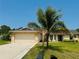 Charming single-story home with a well-manicured lawn, large driveway, and a mature palm tree in the front yard at 3303 Victory Palm Dr, Edgewater, FL 32141