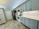 Well-equipped kitchen with gray cabinetry, stainless steel appliances, and stylish tile flooring at 3303 Victory Palm Dr, Edgewater, FL 32141