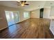 Bright living room featuring wood flooring, a ceiling fan, and sliding glass doors to the sunroom at 3303 Victory Palm Dr, Edgewater, FL 32141