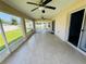 A spacious enclosed patio with tile flooring, screens, ceiling fans, and a view of the backyard at 3303 Victory Palm Dr, Edgewater, FL 32141