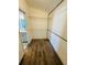 Efficient walk-in closet with wood-look floors, white walls, wire shelves, and pipe clothing rack at 3303 Victory Palm Dr, Edgewater, FL 32141