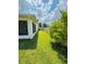 A lush lawn stretches between the side of the house and a white wooden fence at 3303 Victory Palm Dr, Edgewater, FL 32141