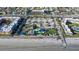 Aerial view of a public beach park with colorful sunshades, a playground, and boardwalk at 3509 S Atlantic Ave # 102 And 103, New Smyrna Beach, FL 32169
