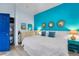 Stylish bedroom with a king-sized bed, bright turquoise accent wall, and coastal-themed decor at 3509 S Atlantic Ave # 102 And 103, New Smyrna Beach, FL 32169