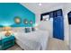 Bright bedroom with a king bed, accent wall, coastal decor, and a view of the windows at 3509 S Atlantic Ave # 102 And 103, New Smyrna Beach, FL 32169