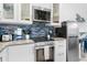 Updated kitchen featuring white cabinets, granite countertops, and stainless steel appliances at 3509 S Atlantic Ave # 102 And 103, New Smyrna Beach, FL 32169