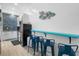 Well-lit kitchen with stainless steel appliances, blue bar stools, and white cabinets at 3509 S Atlantic Ave # 102 And 103, New Smyrna Beach, FL 32169