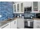 Bright kitchen featuring white cabinets, granite countertops, and stainless steel appliances at 3509 S Atlantic Ave # 102 And 103, New Smyrna Beach, FL 32169