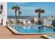 Community pool area with ocean view, palm trees and ample seating at 3509 S Atlantic Ave # 102 And 103, New Smyrna Beach, FL 32169
