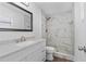 Bathroom with marble-look tiled shower and a white vanity with stone countertop at 3610 Donna St, Port Orange, FL 32129
