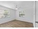 Bedroom featuring wood-look floors, ceiling fan, and natural light from two windows at 3610 Donna St, Port Orange, FL 32129