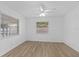 Bright bedroom with wood-look floors, ceiling fan, and natural light from two windows at 3610 Donna St, Port Orange, FL 32129