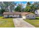 Charming single-story brick home with a well-manicured lawn and a long driveway leading to an attached garage at 3610 Donna St, Port Orange, FL 32129
