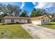 Charming single-story brick home with a well-manicured lawn and a long driveway leading to an attached garage at 3610 Donna St, Port Orange, FL 32129