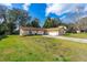 Charming single-story brick home with a well-manicured lawn and a long driveway leading to an attached garage at 3610 Donna St, Port Orange, FL 32129