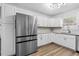 Bright kitchen features stainless steel appliances, white cabinets, and vinyl wood-look floors at 3610 Donna St, Port Orange, FL 32129