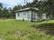 Rear exterior view of the house, showcasing the metal roof and wooden siding at 3625 Pioneer Trl, New Smyrna Beach, FL 32168