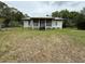 Quaint single-story home featuring a welcoming front porch, and tidy lawn at 3625 Pioneer Trl, New Smyrna Beach, FL 32168