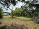 Large yard with mature trees and partial home view, offering a serene and private setting at 3625 Pioneer Trl, New Smyrna Beach, FL 32168
