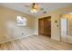 A cozy bedroom with light wood laminate flooring and a ceiling fan for added comfort at 3718 Paige St, Port Orange, FL 32129