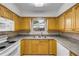 Kitchen featuring oak cabinets, a stainless steel sink, and white appliances at 3718 Paige St, Port Orange, FL 32129