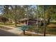 Aerial view of brick home with mature trees, green lawn, and painted driveway at 3736 Paige St, Port Orange, FL 32129