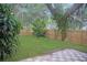 Spacious backyard featuring a well-maintained lawn, wooden fence, and a tiled patio at 3736 Paige St, Port Orange, FL 32129