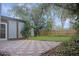 View of backyard featuring a tiled patio, lush green lawn, mature trees and wooden fence at 3736 Paige St, Port Orange, FL 32129