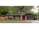 Charming brick home with a well-manicured lawn and a beautiful tree in the front yard at 3736 Paige St, Port Orange, FL 32129