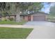 Charming single-story brick home with a red front door, mature landscaping, and a spacious two-car garage at 3736 Paige St, Port Orange, FL 32129