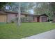 Well-manicured front yard with lush green grass and mature landscaping leading to a brick home at 3736 Paige St, Port Orange, FL 32129