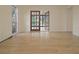 Spacious living room with wood-look flooring, open doorway to another room, and a bright window for natural light at 3736 Paige St, Port Orange, FL 32129