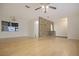Open living room with wood laminate flooring, brick accent wall and ceiling fan at 3736 Paige St, Port Orange, FL 32129