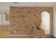 Charming brick accent wall with arched doorway and neutral flooring in the living room at 3736 Paige St, Port Orange, FL 32129