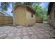 Exterior view of backyard shed with a wooden door and a checkered tile patio at 3736 Paige St, Port Orange, FL 32129