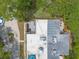 A bird's-eye view of a house showing the rooftop, outdoor patio, and surrounding greenery with nearby driveway at 3808 Saxon Dr, New Smyrna Beach, FL 32169