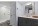 Well-lit bathroom with a gray vanity, shower, and white door at 3808 Saxon Dr, New Smyrna Beach, FL 32169