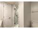 Bathroom featuring a shower with white marble tiling, glass door, and white fixtures at 3808 Saxon Dr, New Smyrna Beach, FL 32169
