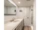 Bathroom featuring sleek gray vanity with marble countertop, framed mirror, and walk-in shower at 3808 Saxon Dr, New Smyrna Beach, FL 32169