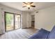 Bedroom features wood-look floors, large closet, ceiling fan and balcony access at 3808 Saxon Dr, New Smyrna Beach, FL 32169