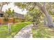 Picturesque view of a home with mature trees, lush landscaping, and a walking path at 3808 Saxon Dr, New Smyrna Beach, FL 32169