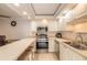 Bright kitchen with white cabinets, stone countertops, seating, and stainless steel appliances at 3808 Saxon Dr, New Smyrna Beach, FL 32169