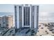Condo building exterior with ample parking, blue signage, and ocean view from this multi-story condo at 3855 S Atlantic Ave # 1503, Daytona Beach Shores, FL 32118