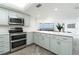 Open concept kitchen featuring stainless steel appliances, white backsplash, and light-blue cabinets at 3855 S Atlantic Ave # 1503, Daytona Beach Shores, FL 32118