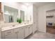 A bathroom with double sinks, decorative plant and neutral paint at 3963 Willowbrook Dr, Edgewater, FL 32141