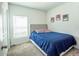 Cozy bedroom with light gray carpet, a blue bedspread, and light-filled window at 3963 Willowbrook Dr, Edgewater, FL 32141