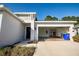 Home exterior featuring a well-maintained lawn, a front door, and an open garage with equipment at 3963 Willowbrook Dr, Edgewater, FL 32141