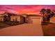 Charming one-story home features a well-manicured lawn and a two-car garage against a striking sunset backdrop at 3963 Willowbrook Dr, Edgewater, FL 32141